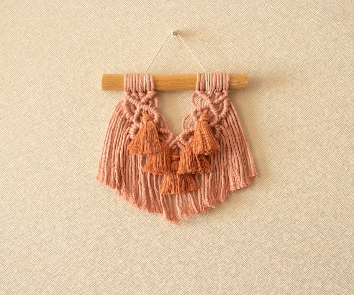 Mini mural de macramé rosado pompones